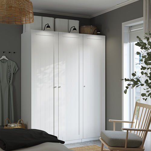 Acogedor dormitorio con armario alto blanco GULLABERG, ventana, silla, alfombra.