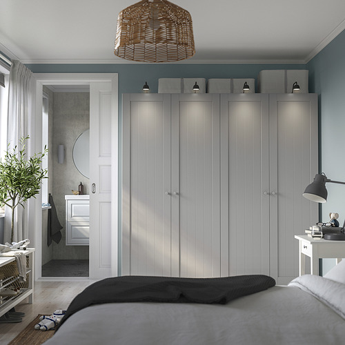 Dormitorio con armarios GULLABERG blancos, bisagras de cierre suave, cama acogedora, escritorio y lámpara colgante de mimbre.