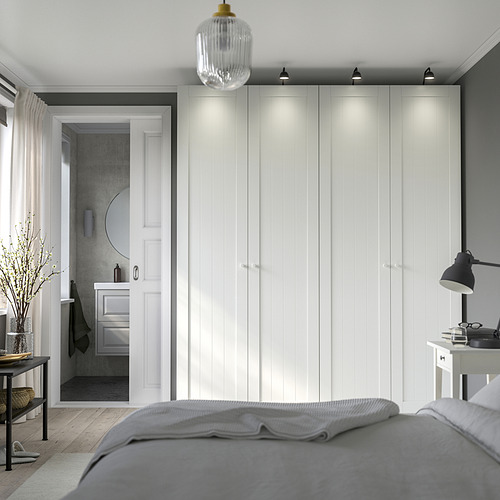Dormitorio moderno con gran armario PAX, luces integradas, ropa de cama gris.