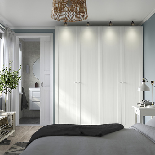 Dormitorio moderno con armario PAX blanco, bisagras de cierre suave, iluminación uniforme y una cama acogedora. Diseño elegante.