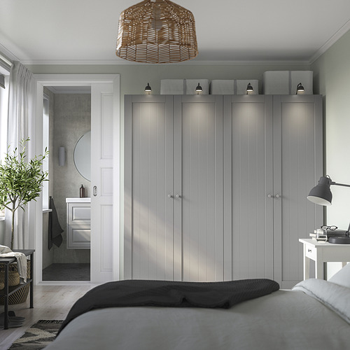Dormitorio minimalista con armario PAX, apliques, lámpara de noche y lavabo de baño de esquina.
