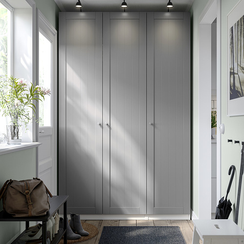 Moderno armario PAX gris con un diseño elegante y minimalista, que se eleva cerca de una ventana y una puerta.