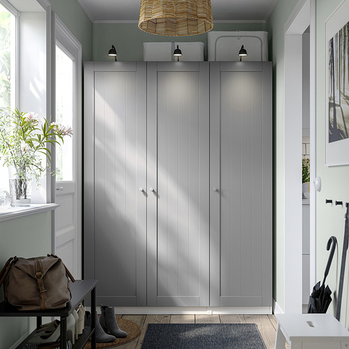 Modern gray PAX wardrobe with pendant light, table, vase, and umbrella stand.