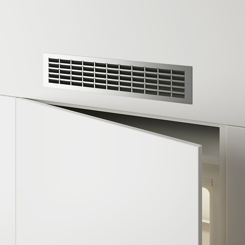 Rejilla de ventilación metálica rectangular montada en una pared blanca sobre una puerta, que permite el flujo de aire.