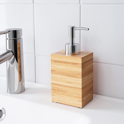Un baño moderno con un grifo cromado y un dispensador de jabón en una caja de madera de bambú.