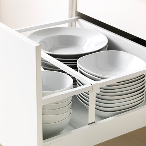 Organizador de cajones de cocina blanco con platos y cuencos apilados, parte del sistema METOD de ikea.
