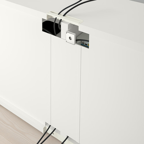 Banco de tv blanco BESTÅ con gestión de cables, estantes ajustables y cajones con función de apertura a presión. Los cables se enrutan cuidadosamente a través de salidas visibles.