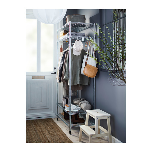Configuración del pasillo con estanterías, ropa, bolso y planta de metal plateado OMAR.