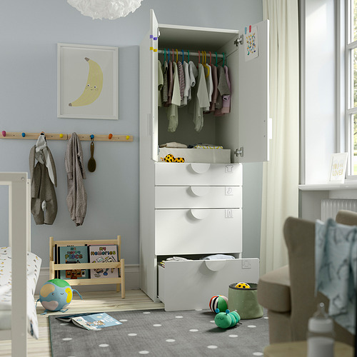 Acogedora habitación para niños con una colorida alfombra en el suelo, un armario y un soporte para libros.