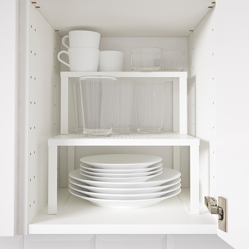 Gabinete de cocina abierto con estantes blancos que muestran platos blancos apilados y vasos transparentes.