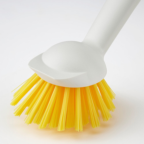 Cepillo de limpieza con cerdas amarillas, mango blanco y ventosa, diseñado para superficies de cocina. Materiales duraderos para un fregado eficiente.