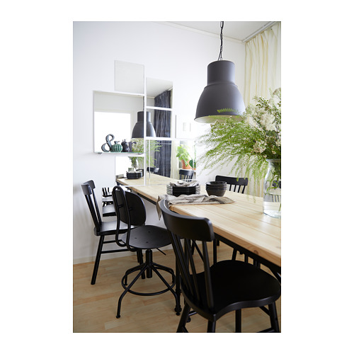 Comedor moderno con sillas giratorias KULLABERG, mesa de madera, lámpara grande, cortinas transparentes y jarrón de flores.