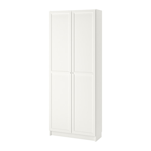 Una estantería blanca de BILLY con puertas. Está hecho de tableros de partículas y tiene un diseño simple y rectangular con estantes ajustables.