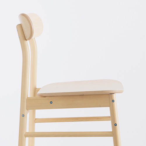 Silla moderna de madera clara con respaldo y asiento curvos, robusta y elegante, perfecta para cenar.