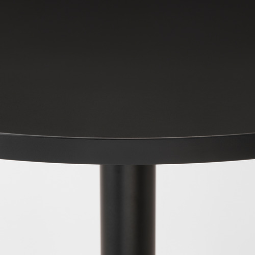 Moderno tablero redondo negro con borde elegante y pata cilíndrica, se asienta firmemente.