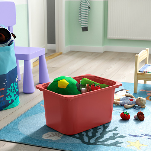 Red TROFAST storage bin on rug with toys for childs room. Easy to access and reorganize.
