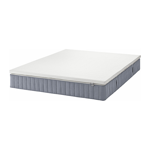 Un colchón blanco de muelles ensacados VALEVÅG de IKEA con bordes grises, rectangular, diseñado para brindar soporte y transpirabilidad.