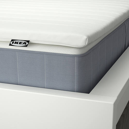 Close-up of IKEA mattress showcasing quality: white quilted top, grey base, and visible branding.