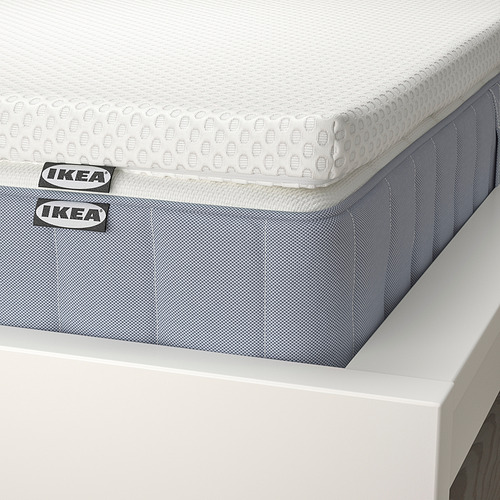 Un juego de colchones de ikea cuidadosamente dispuesto con una capa superior texturizada, que se muestra en un marco blanco, enfatizando su calidad y comodidad.