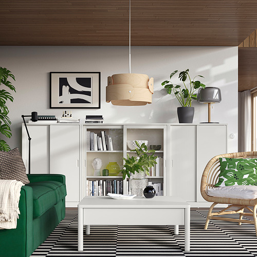 Elegante y moderna sala de estar con sofá verde, armarios blancos TONSTAD, alfombra a rayas y lámpara colgante de madera.