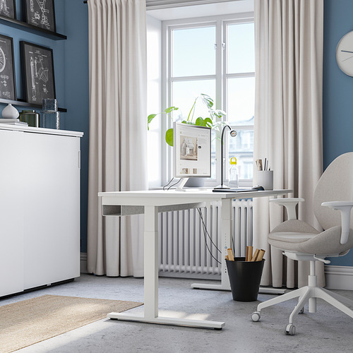 Moderna oficina en casa con escritorio, lámpara, computadora y silla MITTZON junto a una ventana.