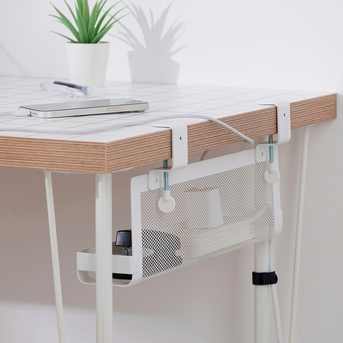 Escritorio de madera con bandeja de cables FÖRSÄSONG blanca, con capacidad para computadora portátil, bolígrafo y planta. La bandeja de cables se conecta debajo del escritorio para un espacio de trabajo organizado.