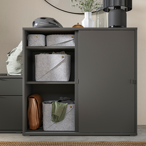 Moderno mueble de almacenaje VIHALS gris con puertas correderas y estantes abiertos para una exposición organizada y un almacenamiento oculto.