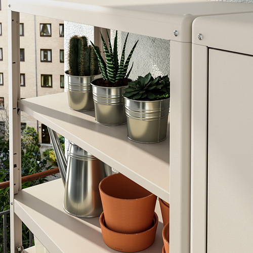 Estantería con macetas metálicas con plantas, ideal para el almacenamiento al aire libre.