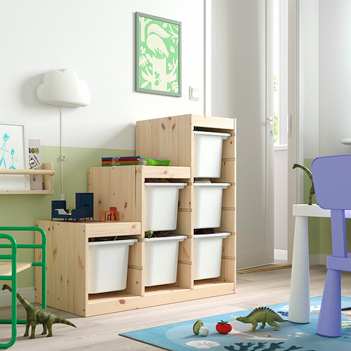 Luminosa habitación para niños con almacenamiento TROFAST: marco de madera clara, contenedores de plástico blanco, juguetes de dinosaurios verdes y alfombra azul. Perfecto para espacios pequeños.