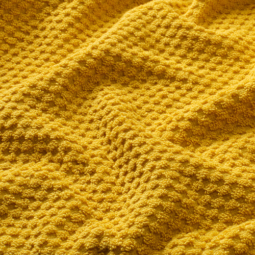 Toalla de rizo suave de color amarillo brillante, mostrando su superficie lujosa y texturizada.
