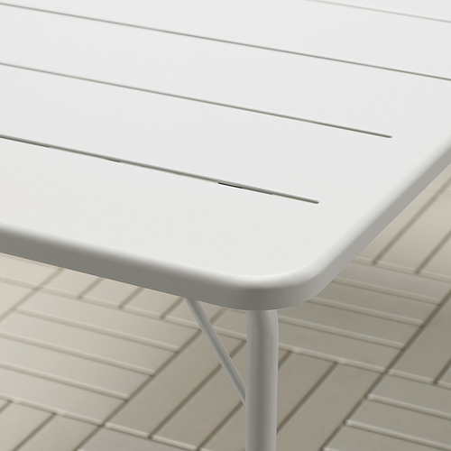 Primer plano de la superficie de las mesas blancas modernas y la elegante pata de metal, que muestra su diseño limpio y materiales duraderos.