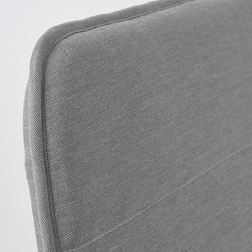Primer plano de una silla moderna tapizada en tela gris, con líneas suaves y limpias y costuras de calidad.