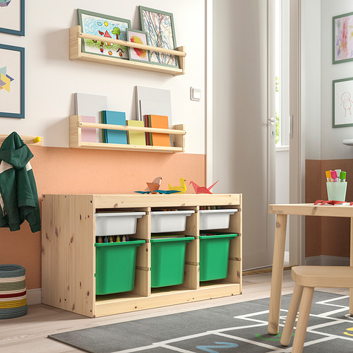 Habitación para niños con almacenamiento de madera clara TROFAST, contenedores verdes y estantes con juguetes y libros coloridos.