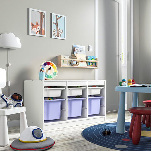 Sala de juegos con unidad de almacenamiento TROFAST blanca, contenedores morados, libros, coloridas obras de arte, mesa de juguetes y juguetes de astronautas.