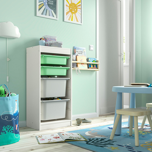 Habitación infantil con cajones TROFAST blancos, estante de pared, mesa azul y decoración.