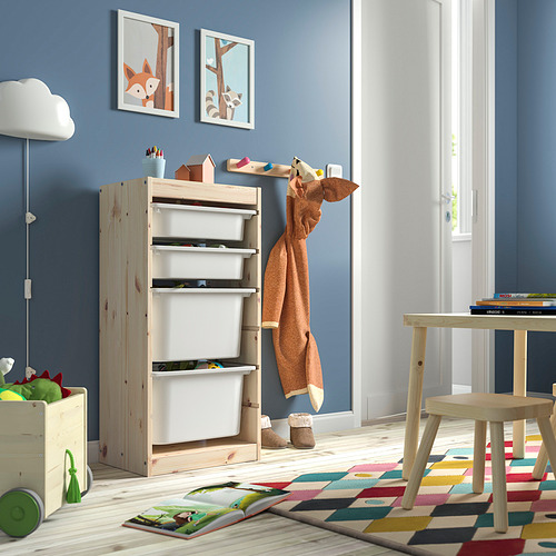 Habitación para niños con unidad de almacenamiento de pino claro TROFAST con cajas blancas. Alfombra brillante, juguetes coloridos y decoración sencilla.