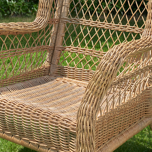 Silla de patio de mimbre tejido que muestra una artesanía intrincada, destacando su diseño duradero y resistente a la intemperie.
