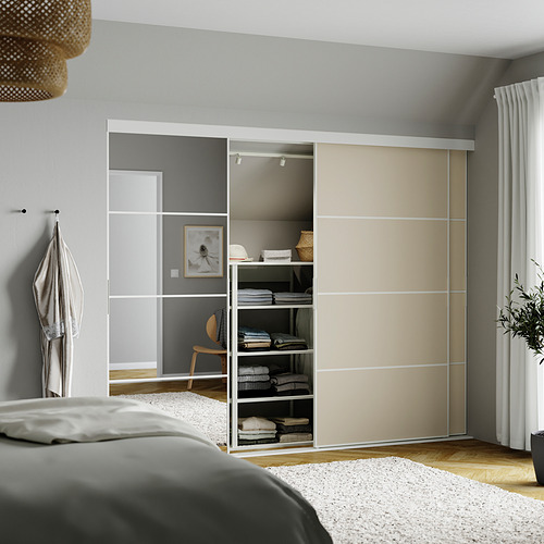 Dormitorio moderno con amplio armario corredero SKYTTA en color beige y gris. Paneles de espejo, ropa limpia, luz colgante de mimbre sobre la cama.