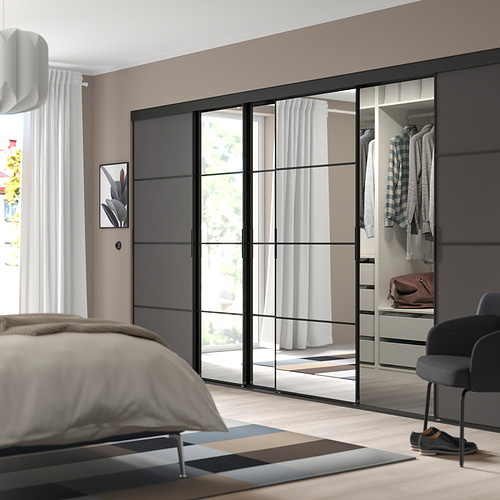Dormitorio moderno con puertas de armario elegantes y grandes, líneas horizontales y marco negro. Percha y ropa almacenada, cama beige, silla oscura, alfombra de rayas.