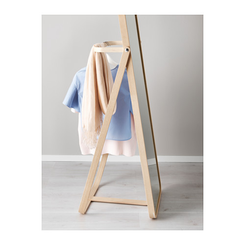 Un espejo con marco de madera y un gancho sostiene la ropa, lo que ahorra tiempo al mostrar el atuendo del día siguiente.