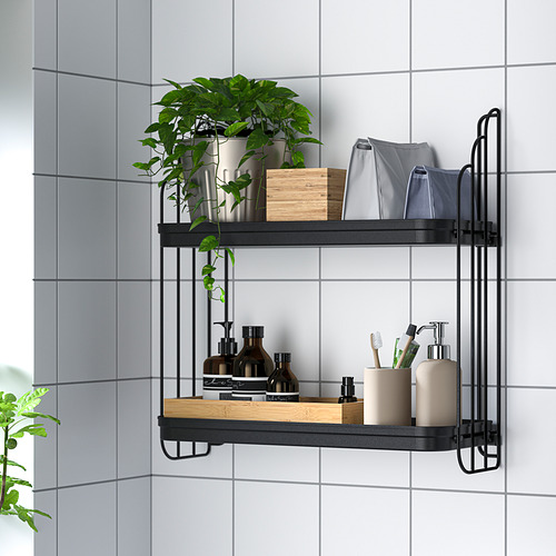 Estantería de pared con dos niveles que almacenan artículos de baño: botellas, cepillos de dientes, toallas y una planta en una habitación con azulejos.