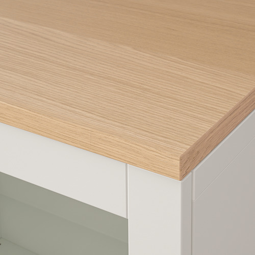 Primer plano de la mesa de madera clara sobre un mueble blanco, que muestra un acabado suave y artesanía.