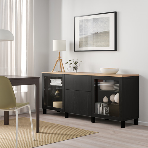 Modern living room with BESTÅ black sideboard, beach art, green chairs, lamp, and rug.