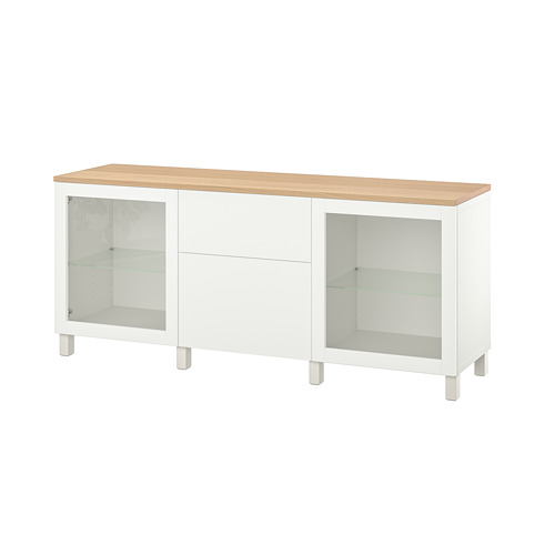 Esta imagen muestra un aparador blanco BESTÅ con puertas de cristal y tapa de madera.