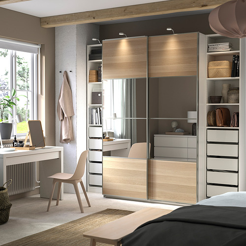 Dormitorio moderno con armario PAX, madera clara, puertas correderas, escritorio, silla, estanterías organizadas.
