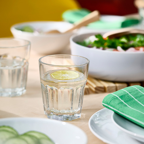 Vaso de vidrio transparente con rodaja de limón, parte de la serie POKAL. Resistente, apto para lavavajillas, perfecto para bebidas refrescantes.