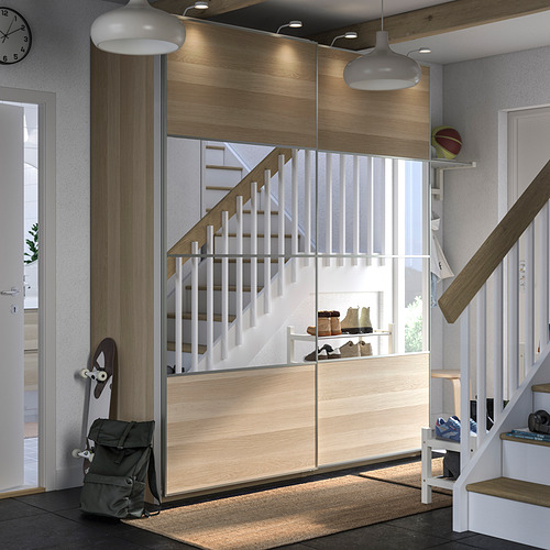 Entrada moderna con almacenamiento de madera PAX. Escaleras, patines, bolsos y un reloj. Aspecto limpio y organizado.