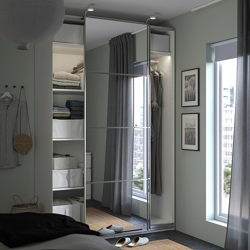 Dormitorio moderno con puertas corredizas reflectantes en el armario, almacenamiento organizado y decoración minimalista.