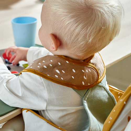 Niño con babero de puntos para la alimentación, delantero impermeable, espalda de algodón suave.