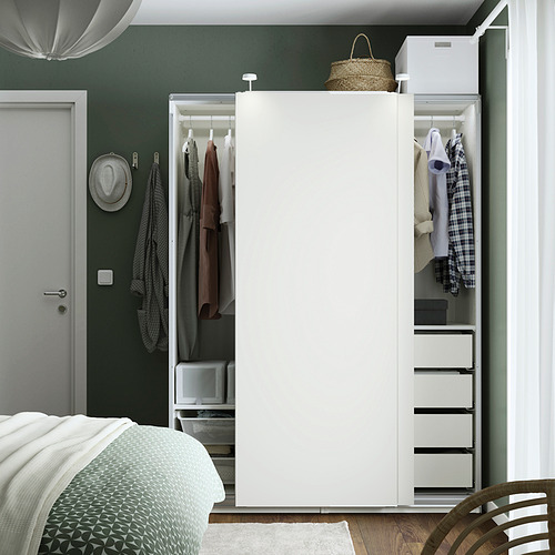 Dormitorio con armario abierto, paredes de color verde oscuro y cama estampada.